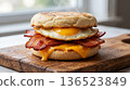 English muffin sandwich with crispy bacon, fried egg, and cheese 136523849