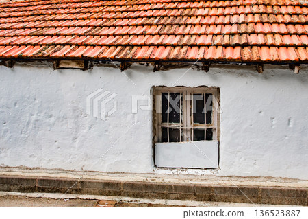 window in old house with tiled roof 136523887