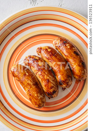 Glazed chicken sausages arranged on decorative plate with warm caramelized finish Glazed chicken sausages arranged on decorative plate with warm caramelized finish 136523911