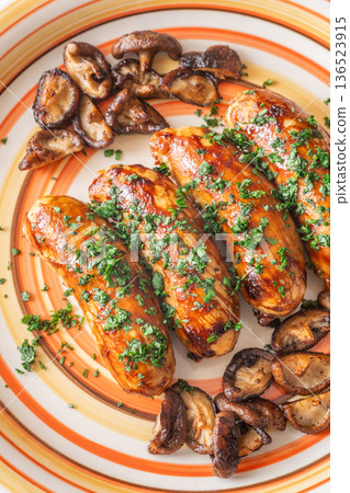 Glazed chicken sausages with herbs and mushrooms on decorative plate studio food Glazed chicken sausages with herbs and mushrooms on decorative plate studio food 136523915