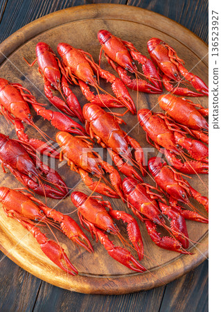 Top down boiled crawfish arranged on wooden board with lemon wedges, rustic background Top down boiled crawfish arranged on wooden board with lemon wedges, rustic background 136523927