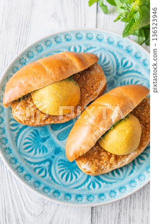 Vada Pav Indian street food served on blue plate in bright overhead composition Vada Pav Indian street food served on blue plate in bright overhead composition 136523946