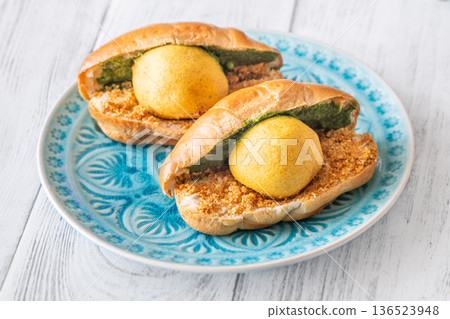 Vada Pav Indian street food served on blue plate in bright overhead composition Vada Pav Indian street food served on blue plate in bright overhead composition 136523948
