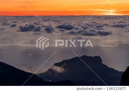 Orange sunrise sky above a cloud covered ocean from Pico do Arieiro, Madeira 136523977