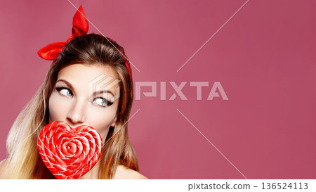 Woman Pin-Up Enjoying Heart Lollipop, Playful Portrait With Red Bandana, Glossy Lipstick, Pink Background, CloseUp Framing, Flirtatious Sideways Gaze, Vintage Style, Commercial Beauty, Valentines Day Woman Pin-Up Enjoying Heart Lollipop, Playful Portrait With Red Bandana, Glossy Lipstick, Pink Background, CloseUp Framing, Flirtatious Sideways Gaze, Vintage Style, Commercial Beauty, Valentines Day 136524113