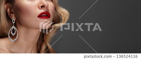 Cropped Caucasian Woman Showcasing Chandelier Earrings, Bold Red Lips, Sculpted Jawline, Glittering Diamonds Against Matte Grey Backdrop, Highend Fashion Campaign, Poised Refined Expression, Beauty 136524116