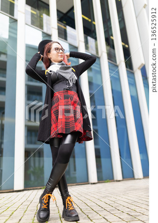 Young woman confidently standing in modern city environment 136525912