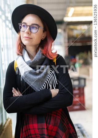 Young woman with glasses and hat looking away reflecting Young woman with glasses and hat looking away reflecting 136525936