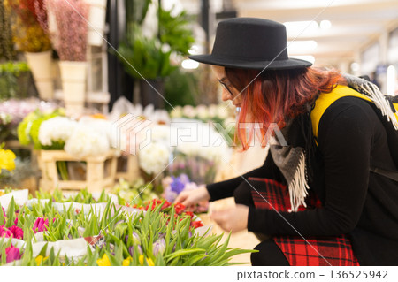 Young woman selecting colorful tulips in flower market 136525942