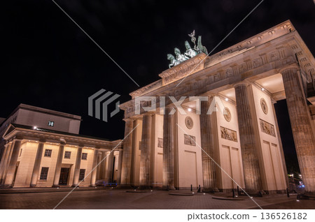 Berlin, germany, august 13, 2023. Brandenburg gate in berlin illuminated at night, showcasing the neoclassical columns and quadriga statue against dark sky 136526182