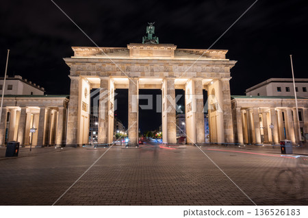 Berlin, germany, august 13, 2023. Brandenburg gate in berlin glowing against the night sky, neoclassical monument and symbol of german unity and history, empty street 136526183