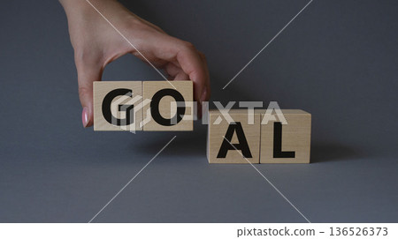 Goal symbol. Concept word Goal on wooden cubes. Beautiful grey background. Businessman hand. Business and Goal concept. Copy space. Goal symbol. Concept word Goal on wooden cubes. Beautiful grey background. Businessman hand. Business and Goal concept. Copy space. 136526373