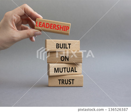 Leadership symbol. Wooden blocks with words Leadership Built on Mutual Trust. Businessman hand. Beautiful grey background. Business and Leadership concept. Copy space 136526387