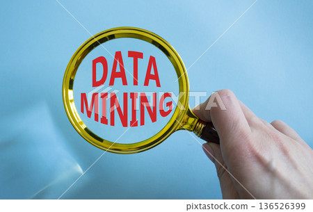 Data Mining symbol. Magnifying Glass with words Data Mining. Beautiful blue background. Businessman hand. Business and Data Mining concept. Copy space. 136526399