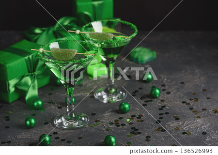 Green Cocktails with Lime,  Gifts and Confetti. Festive St. Patricks Day Celebration Still Life 136526993