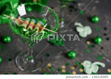 Green Cocktails with Rainbow Candy, shamrocks, Gifts and Confetti. Festive St. Patricks Day Celebration Still Life 136526995