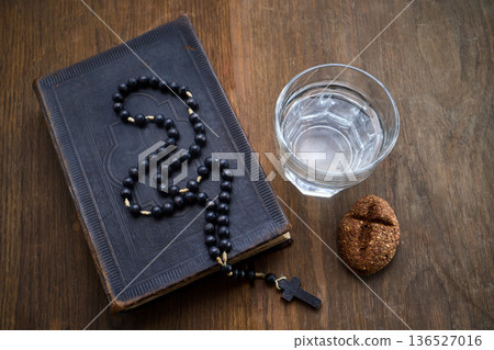 Bible, rosary, water, bread symbolizing lenten fasting and prayer Bible, rosary, water, bread symbolizing lenten fasting and prayer 136527016