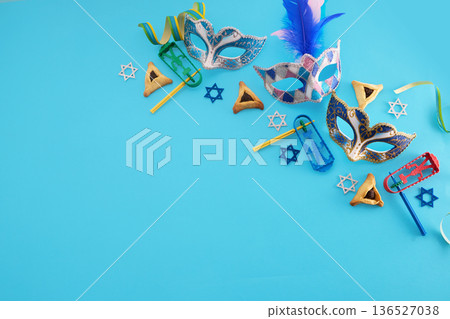 Purim traditional masks, hamantaschen, graggers on blue background 136527038