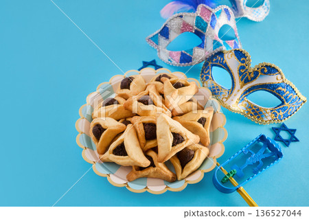 Purim celebration objects including hamantaschen, masks, and gragger Purim celebration objects including hamantaschen, masks, and gragger 136527044