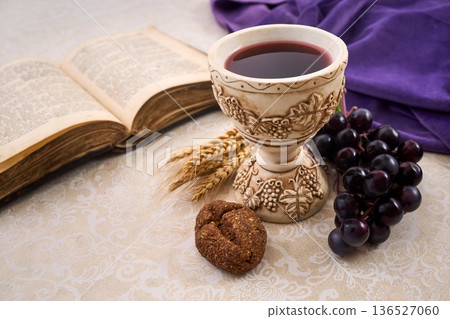 Holy communion with chalice, wine, bread, grapes, bible, symbolizing religion Holy communion with chalice, wine, bread, grapes, bible, symbolizing religion 136527060