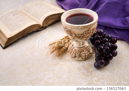 Chalice with wine, grapes, wheat, and bible for communion 136527063