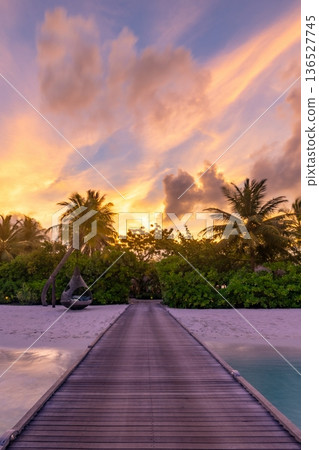 Breathtaking Maldives sunset wooden pier leads to tropical paradise beach sky Breathtaking Maldives sunset wooden pier leads to tropical paradise beach sky 136527745