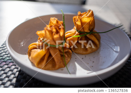 Gourmet blini pouches tied with fresh chives Gourmet blini pouches tied with fresh chives 136527836