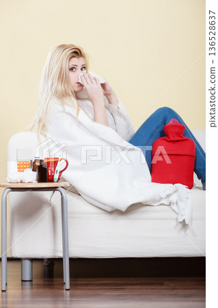 Woman being sick having flu lying on sofa Woman being sick having flu lying on sofa 136528637