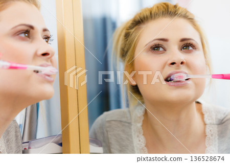 Woman brushing cleaning teeth in bathroom 136528674