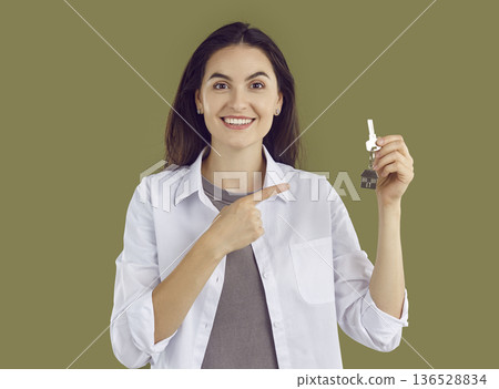 Happy young woman showing keys moving to new apartment or house 136528834