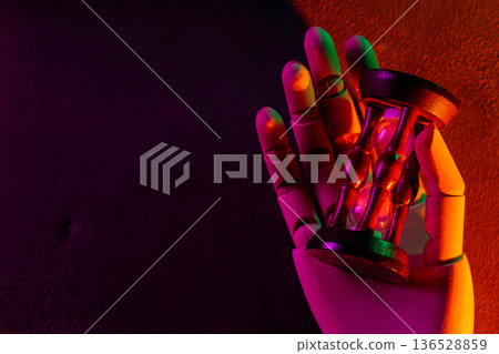 Futuristic Robotic Hand Holding Hourglass in Vibrant Purple Orange Green Neon Lighting Futuristic Robotic Hand Holding Hourglass in Vibrant Purple Orange Green Neon Lighting 136528859