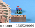 10,000 yen bill, miniature house, and LOAN letter block Light blue background (image of mortgage loan) 136529069