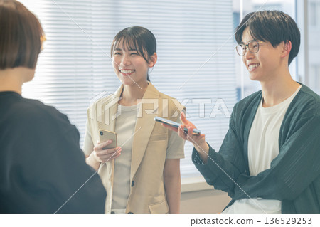 Men and women chatting in the office Men and women chatting in the office 136529253