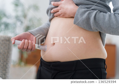 一名女子將減肥藥注射到腹部(自行注射) 一名女子將減肥藥注射到腹部(自行注射) 136529394