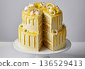 A professional studio shot of a two-tier lemon drip cake with a slice removed to reveal moist sponge layers and yellow curd filling.  136529413