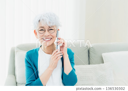 Senior woman talking on landline phone Senior woman talking on landline phone 136530302