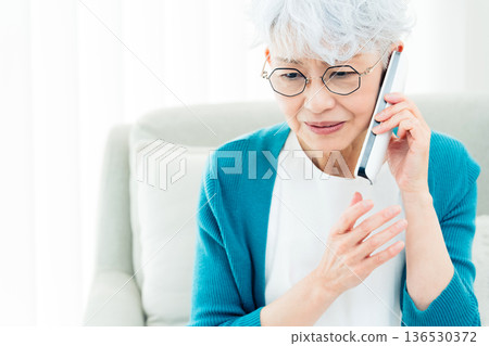 Senior woman talking on landline phone 136530372