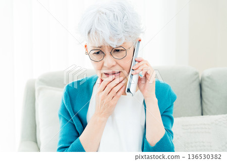 Senior woman talking on landline phone 136530382