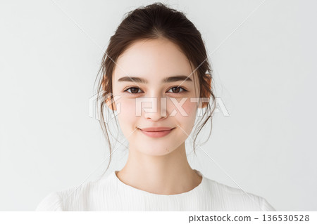 一位面帶微笑的年輕女子在簡潔的背景前肖像畫——一幅清新自然的唯美畫面。 136530528