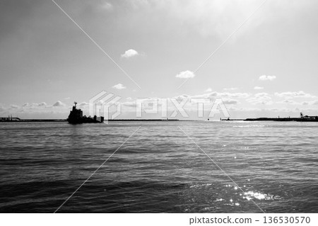 A cargo ship leaving the pier at Tomakomai West Port on a clear winter day and the light reflected on the sea surface "black and white" A cargo ship leaving the pier at Tomakomai West Port on a clear winter day and the light reflected on the sea surface "black and white" 136530570