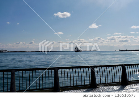 A cargo ship leaves the pier at Tomakomai West Port on a clear winter day and heads out to sea. A cargo ship leaves the pier at Tomakomai West Port on a clear winter day and heads out to sea. 136530573