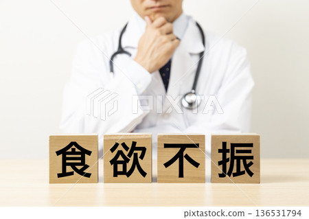 A doctor worries about a block that reads "anorexia" A doctor worries about a block that reads "anorexia" 136531794