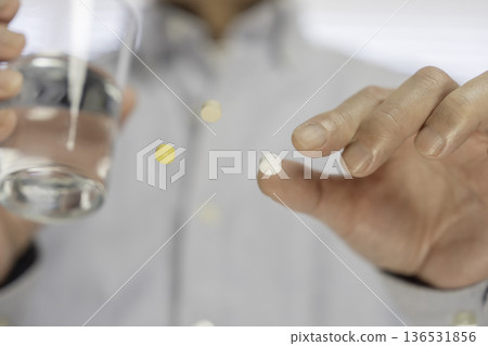 Close-up of a white pill being pinched between fingers before taking it Close-up of a white pill being pinched between fingers before taking it 136531856