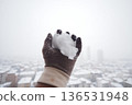 Snowball in hand during winter in city 136531948