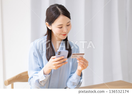 一名女子手持信用卡和智慧型手機 136532174