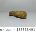 Ginger Root on White Background. Close-up of a single piece of ginger root placed on a plain white surface with a clean white background. The ginger features a rough, tan-colored exterior with natural 136533491