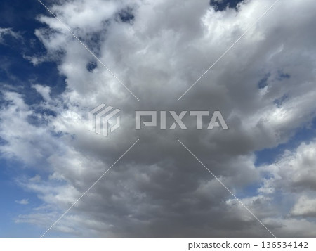 A dramatic and dynamic skyscape created by the powerful cumulonimbus, cumulonimbus, and stratocumulus clouds that spread across the clear blue sky. 136534142