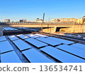 Snow-covered solar panels and a blue winter sky 136534741