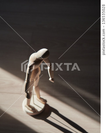 陽光透過窗戶照進屋裡，映照著一個無精打采的人體模型。 136535028