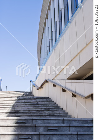 Modern architectural exterior with blue sky and curved design. Urban landscape with copy space. Modern architectural exterior with blue sky and curved design. Urban landscape with copy space. 136535223